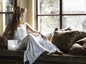 Woman sitting on windowsill, looking outside.