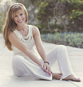 A woman sitting on the ground wearing white pants.